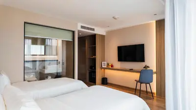 a hotel room with two beds and a flat screen tv at Laya Resort - Forest View Studio in Layan Beach