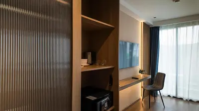 a hotel room with a desk and a window at Laya Resort - Forest View Studio in Layan Beach