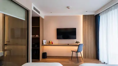 a room with a television on a wall with a chair at Laya Resort - Forest View Studio in Layan Beach