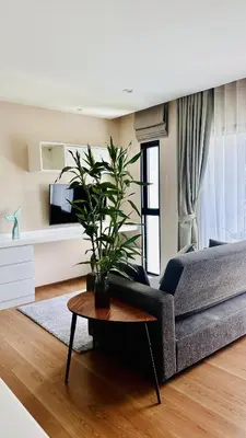 a living room with a couch and a table with a plant at Title V - 1 br Bamboo Rawai Apartment in Karon Beach