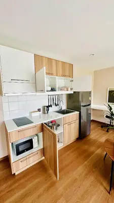 a kitchen with wooden cabinets and a stainless steel refrigerator at Title V - 1 br Bamboo Rawai Apartment in Karon Beach
