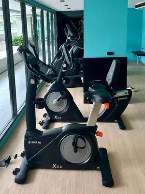 a gym with two exercise bikes in a room at Flat near the beach with gym, pool, sauna and workspace in Ban Thalat Choeng Thale