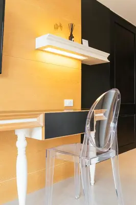 a clear chair sits in front of a desk at Vivace Hotel in Kamala Beach