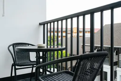 two chairs and a table on a balcony with a coffee cup at Vivace Hotel in Kamala Beach