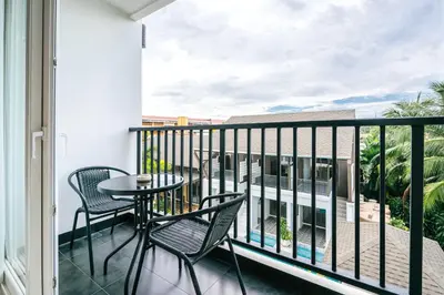 a balcony with a table and chairs and a view at Vivace Hotel in Kamala Beach