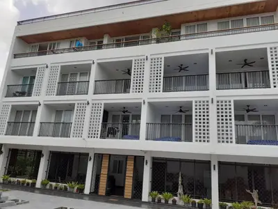 an exterior view of a white building with windows at Vivace Hotel in Kamala Beach