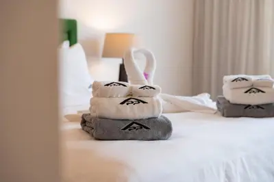 two towels are stacked on top of a bed at Stylish 2BR Resort Condo with Seaview Surin in Phuket Town