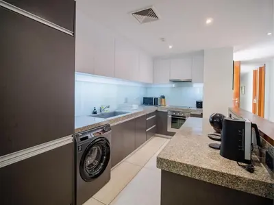 a kitchen with a washer and dryer on a counter at Stylish 2BR Resort Condo with Seaview Surin in Phuket Town