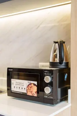 a microwave with a tea kettle on top of it at Beachfront 1524 Wyndham Gardens Condo Naithon in Phuket Town