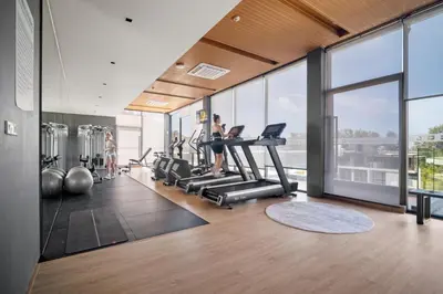 a gym with a woman exercising on treadmills at Beachfront 1524 Wyndham Gardens Condo Naithon in Phuket Town