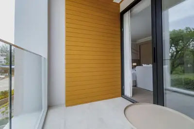 a room with a wooden wall and a chair at Wyndham Gardens 2413 Elegant Studio Forest View in Phuket Town