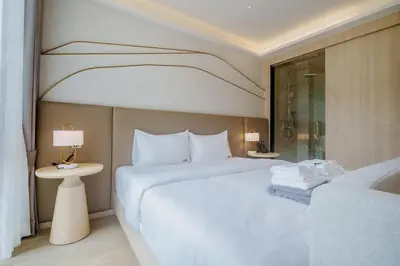 a hotel room with a large white bed and a window at Wyndham Gardens 2413 Elegant Studio Forest View in Phuket Town