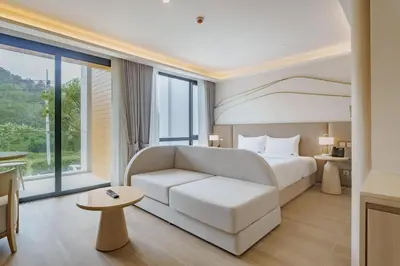 a bedroom with a white bed and a white couch at Wyndham Gardens 2413 Elegant Studio Forest View in Phuket Town