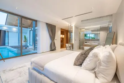 a bedroom with a large bed and a swimming pool at Botanica Aroon Luxury Pool Villa 3 BR Lagoona Bangtao beach in Ban Pak Lak