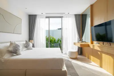 a hotel room with a bed and a television at Botanica Aroon Luxury Pool Villa 3 BR Lagoona Bangtao beach in Ban Pak Lak