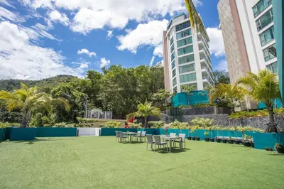 a lawn with tables and chairs in front of a building at Studio Apt Seaview Balcony - Oceana C63 in Kamala Beach