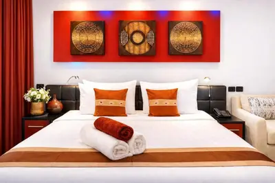 a bedroom with a large white bed with orange pillows at Bangla Jacuzzi Suite 212 in Patong Beach