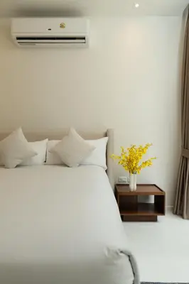 a bedroom with a white bed and a night stand at Phang nga Villas Private Pool & Tropical Retreats