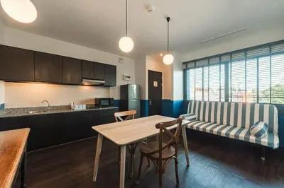 a kitchen and dining room with a table and a couch at Blu Monkey Boutique Naiharn Beach in Nai Harn Beach