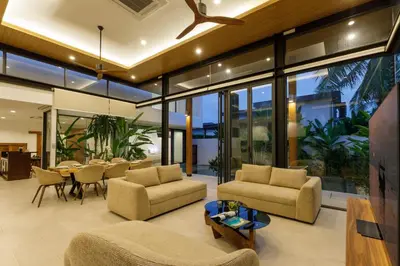 an open living room with a table and chairs at Luxe & Privacy Orchard Villas Pasak 4BR in Laguna Phuket