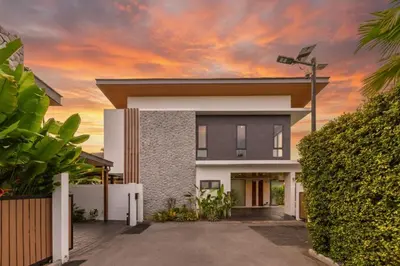 a house with a sunset in the background at Luxe & Privacy Orchard Villas Pasak 4BR in Laguna Phuket