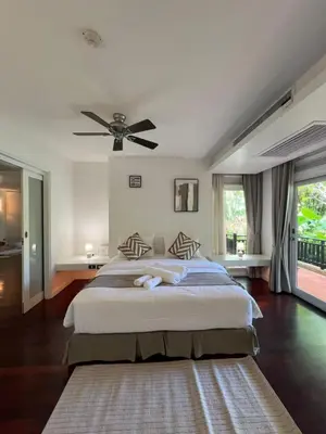 a bedroom with a large bed with a ceiling fan at Spacious 3 bedroom, 100m walk to Layan Beach in Phuket