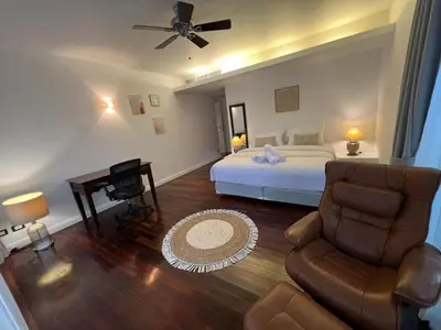 a bedroom with a bed and a couch and a chair at Spacious 3 bedroom, 100m walk to Layan Beach in Phuket