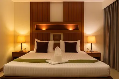 a bedroom with a large white bed with two lamps at The Aura Patong in Patong Beach