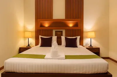 a bedroom with a large bed with two lamps at The Aura Patong in Patong Beach