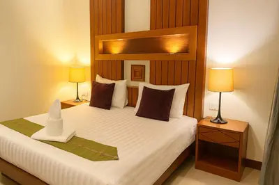 a bedroom with a large bed with two lamps at The Aura Patong in Patong Beach