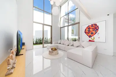 a white living room with a white couch and windows at Modern and elegant 4-bedroom pool villa suitable for families - V10 in Ban Pak Lak
