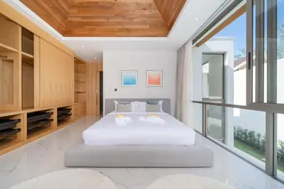 a bedroom with a white bed and a large window at Modern and elegant 4-bedroom pool villa suitable for families - V10 in Ban Pak Lak