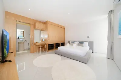 a bedroom with a bed and a couch in a room at Modern and elegant 4-bedroom pool villa suitable for families - V10 in Ban Pak Lak