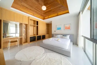 a bedroom with a white bed and a wooden ceiling at Modern and elegant 4-bedroom pool villa suitable for families - V10 in Ban Pak Lak