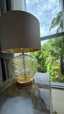 a lamp sitting on a table next to a window at The Ozon Condotel by SP in Laguna Phuket