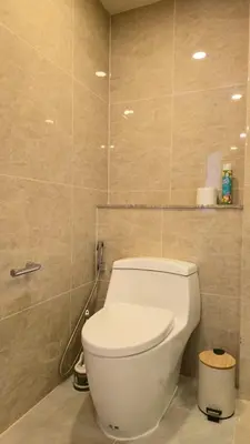 a bathroom with a white toilet in a room at The Ozon Condotel by SP in Laguna Phuket