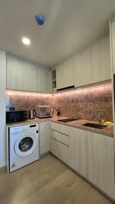 a kitchen with a washing machine and a washer at The Ozon Condotel by SP in Laguna Phuket