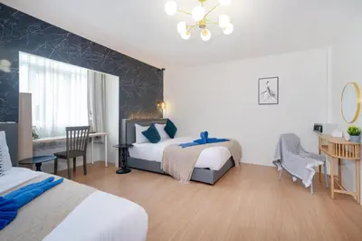 a bedroom with two beds and a table and a desk at Chill Beach Bangla comfy bed and pool 3 bedrooms 10pax in Patong Beach