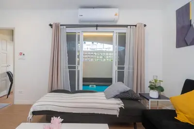 a bedroom with a bed and a large window at Chill Beach Bangla comfy bed and pool 3 bedrooms 10pax in Patong Beach