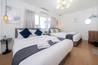 a hotel room with two beds and a window at Chill Beach Bangla comfy bed and pool 3 bedrooms 10pax in Patong Beach