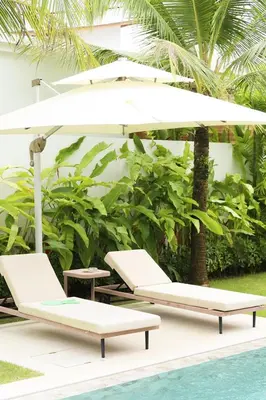 two lounge chairs and an umbrella next to a pool at Phuket luxury Asherah villa Bang Tao in Ban Phru Champa