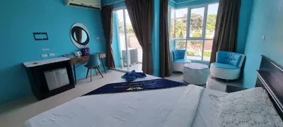a blue bedroom with a bed and a desk and chairs at Bedroom201 Kata Beach Phuket in Kata Beach