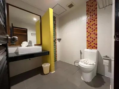a bathroom with a white toilet and a sink at Zephyr Suites in Patong Beach