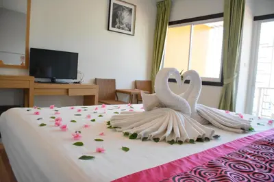 two white swansrendered to look like they are kissing on a bed at Zephyr Suites in Patong Beach