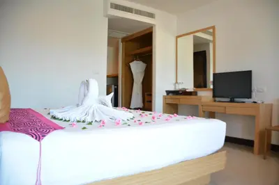 a bedroom with a bed with a dress on it at Zephyr Suites in Patong Beach