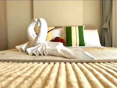 a bed with two swan towels on it at Work & Travel in Kathu