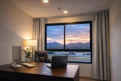a office with a desk with a laptop and a large window at Work & Travel in Kathu