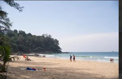 a group of people on a beach near the ocean at Brickotel Naithon Beach in Nai Thon Beach