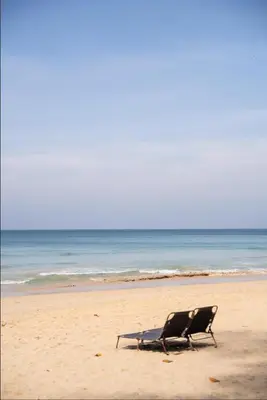 a beach chair sitting on the sand on the beach at Brickotel Naithon Beach in Nai Thon Beach