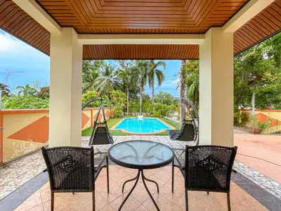 a patio with a table and chairs and a playground at The Beige Pool Villa Bang Tao Phuket in Ban Thalat Choeng Thale